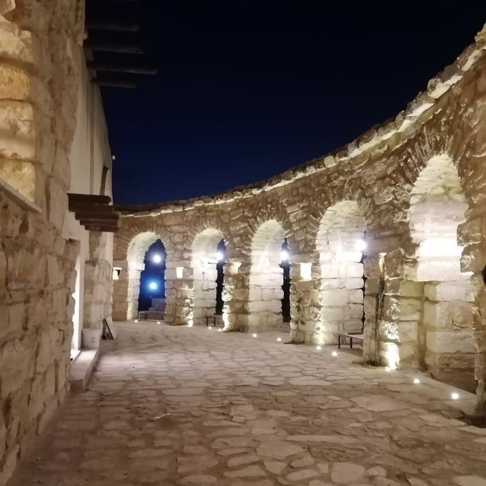 رواق حجري معقود مضاء ليلًا